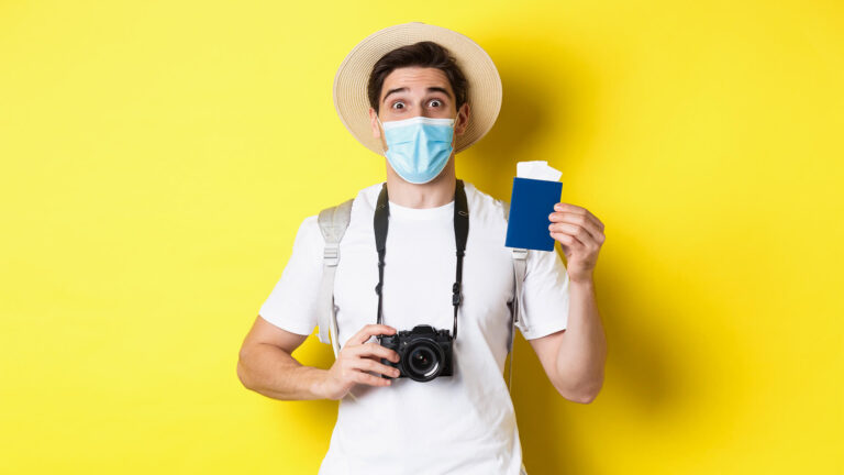 concept-covid-19-travelling-quarantine-happy-man-tourist-with-camera-showing-passport-tickets-vacation-going-trip-during-pandemic-yellow-background_cambodia